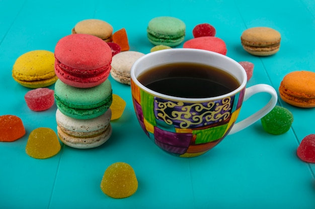 Photo gratuite vue latérale d'une tasse de café et de sandwichs aux biscuits sur fond bleu