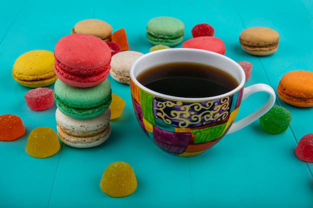 Vue latérale d'une tasse de café et de sandwichs aux biscuits sur fond bleu