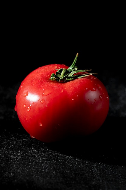 Photo gratuite vue latérale de la tomate humide mûre sur fond noir