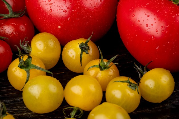 Vue latérale des tomates jaunes et rouges sur une surface en bois