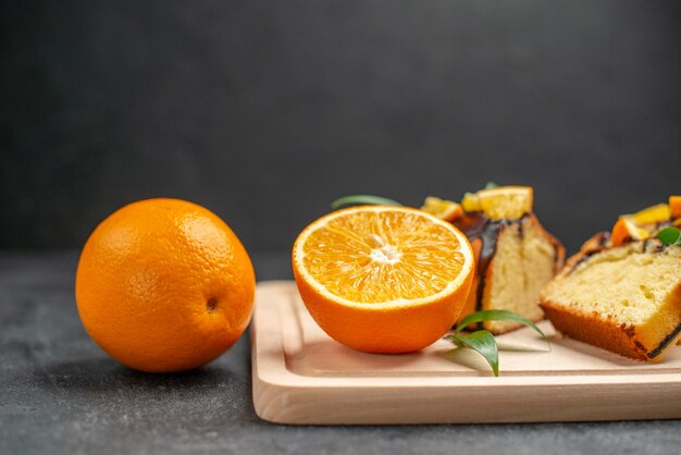 Vue latérale des tranches de citron frais et des tranches de gâteau hachées fraîchement cuites sur table sombre