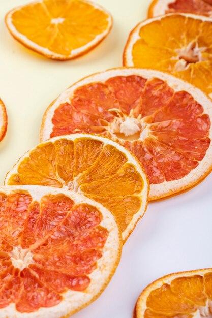 Vue latérale de tranches d'orange et de pamplemousse séchées disposées sur fond blanc