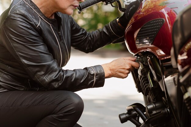 Vue latérale vieille femme cool avec moto