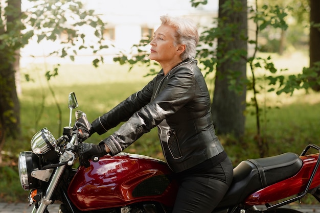 Photo gratuite vue latérale, vieille femme cool avec moto