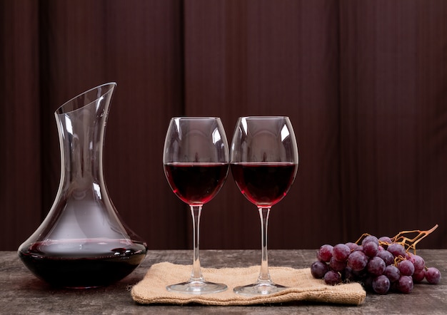 Photo gratuite vue latérale vin rouge en verre avec raisin horizontal