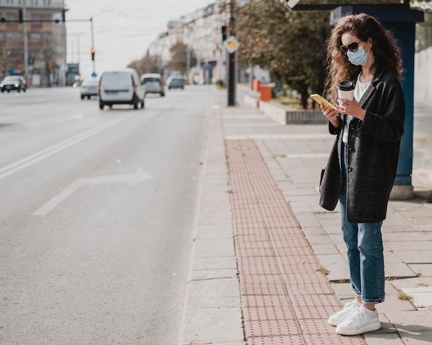 Vue longue femme en attente dans la gare routière