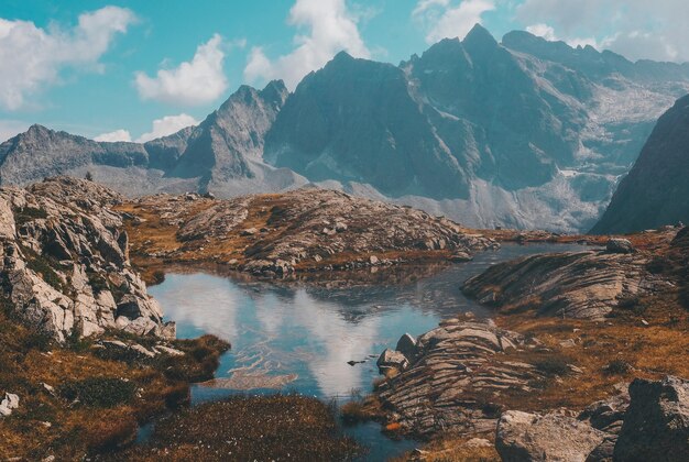 Vue magnifique sur un lac calme entouré de montagnes pendant la journée