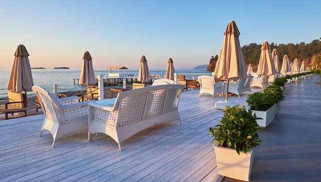 Vue panoramique sur la plage de sable sur la plage avec chaises longues et parasols ouverts sur la mer et les montagnes. Hôtel. Recours. Tekirova-Kemer. dinde