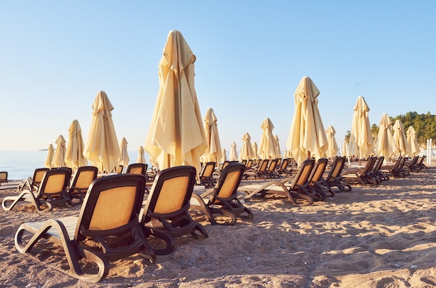 Vue Panoramique Sur La Plage De Sable Privée Avec Chaises Longues Et Parasokamy La Mer Et Les Montagnes. Recours.