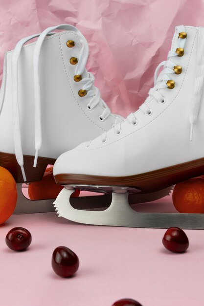 Photo gratuite vue sur patins à glace blancs avec cerises et mandarines