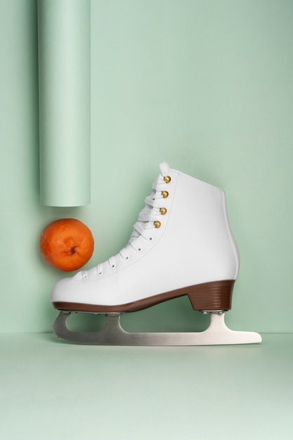 Photo gratuite vue des patins à glace blancs avec des mandarines
