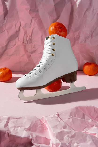 Photo gratuite vue des patins à glace blancs avec des mandarines