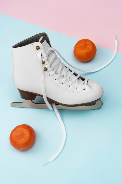 Vue des patins à glace blancs avec des mandarines