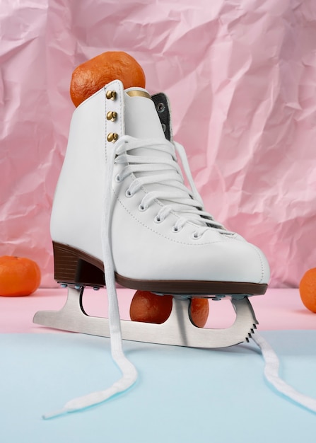 Photo gratuite vue des patins à glace blancs avec des mandarines