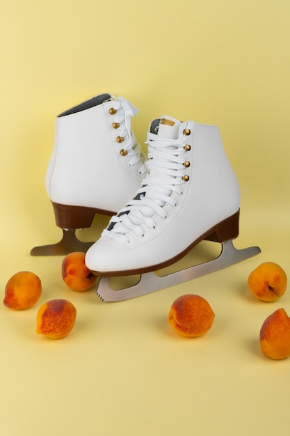 Photo gratuite vue des patins à glace blancs avec des pêches