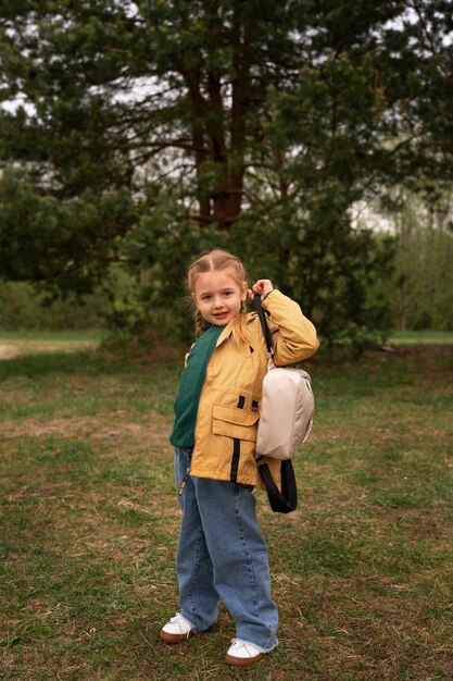 Vue d'une petite fille avec un sac à dos s'aventurant dans la nature