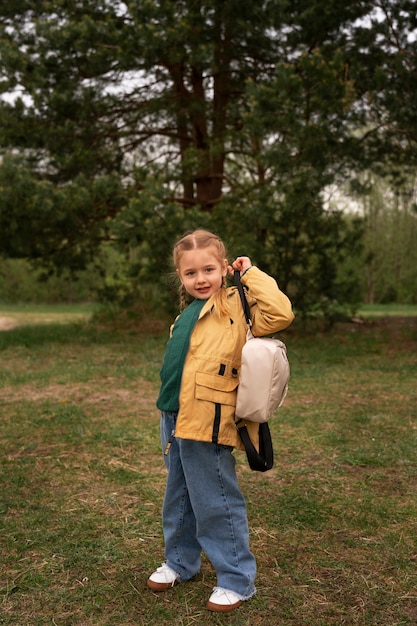 Vue d'une petite fille avec un sac à dos s'aventurant dans la nature