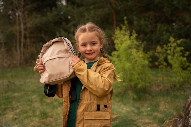 Vue d'une petite fille avec un sac à dos s'aventurant dans la nature