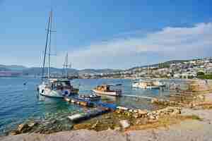 Photo gratuite vue sur la plage de bodrum mer égée maisons blanches traditionnelles fleurs marina bateaux à voile