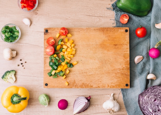 Une vue de la planche à découper avec des légumes hachés sur une table en bois