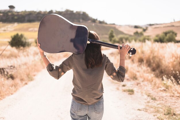 Vue postérieure, de, a, adolescente, à, guitare, debout, sur, chemin terre