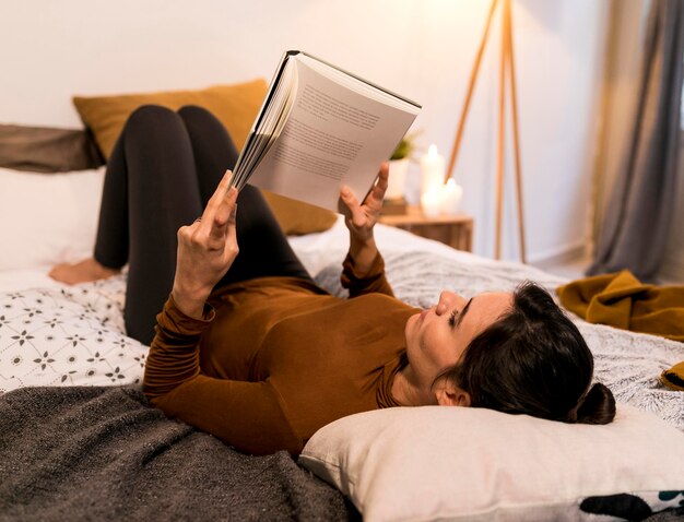 Vue postérieure, femme, lecture livre, dans lit