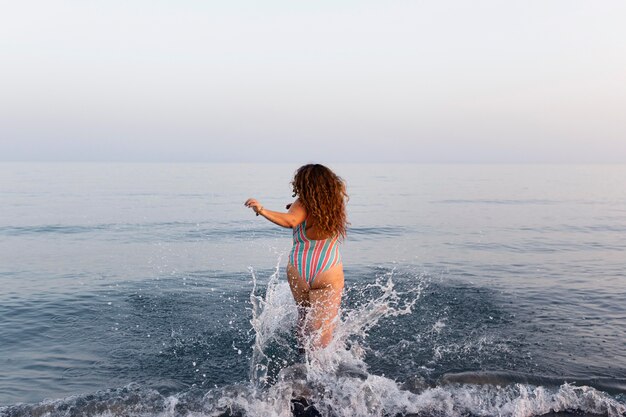 Vue postérieure, de, femme plage, aller, dans, eau