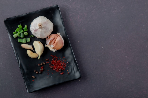 Vue rapprochée de l'assiette de légumes comme l'ail échalote avec des épices sur fond marron avec copie espace