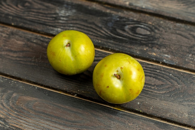 Photo gratuite vue rapprochée avant de la cerise verte-prunes fruits moelleux et aigres sur le fond brun fruit vitamine