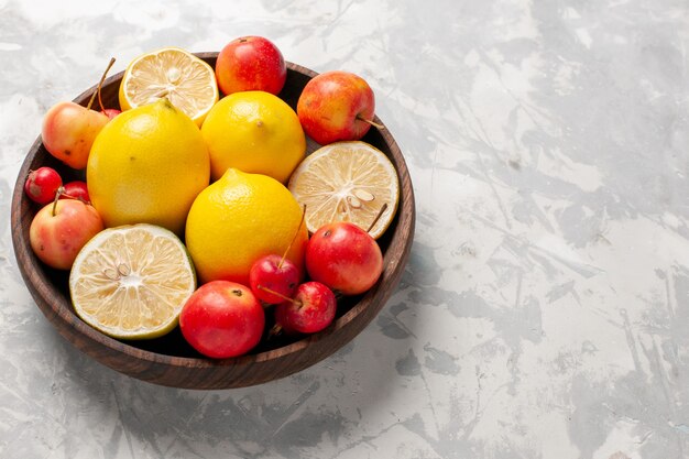 Vue rapprochée avant de citrons frais entiers et tranchés sur un espace blanc