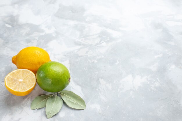 Vue rapprochée avant de citrons frais juteux et aigre sur le bureau blanc tropique fruits exotiques agrumes