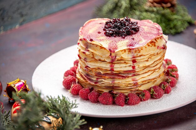 Vue rapprochée avant de délicieuses crêpes à la gelée avec des fraises fraîches sur un espace sombre