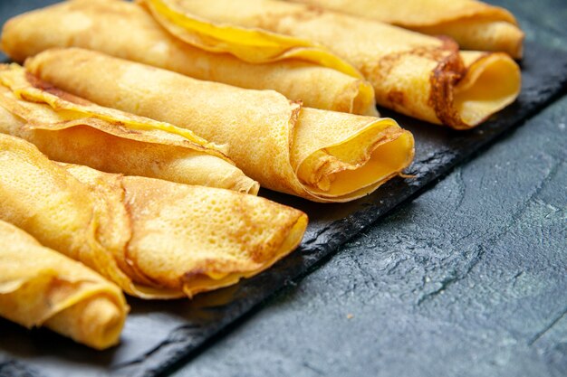 Vue rapprochée de l'avant de délicieuses crêpes roulées bordées d'une tarte aux repas de couleur foncée