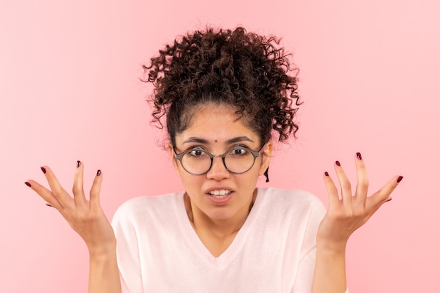 Photo gratuite vue rapprochée avant de jeune femme confuse sur rose