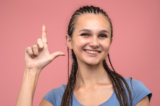 Photo gratuite vue rapprochée avant jeune fille souriante sur rose