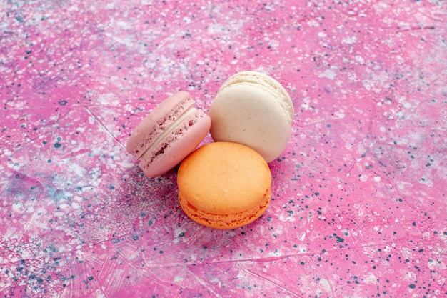 Vue rapprochée avant macarons français délicieux petits gâteaux sur bureau rose