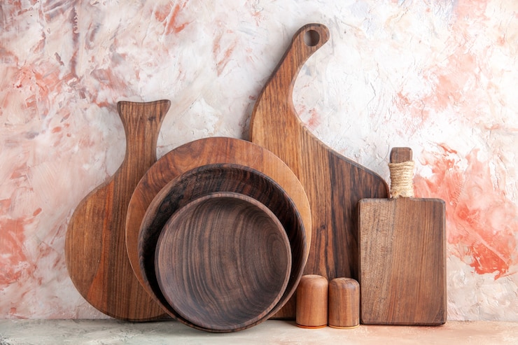 Photo gratuit vue rapprochée avant des planches à découper en bois des pots de sel et de poivre sur une table colorée