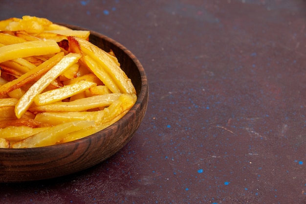 Vue rapprochée avant de pommes de terre frites savoureuses frites à l'intérieur de la plaque sur la surface sombre nourriture repas dîner plat ingrédients pommes de terre