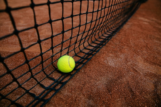 Vue rapprochée d&#39;une balle de tennis pris dans le filet. Sur le terrain.