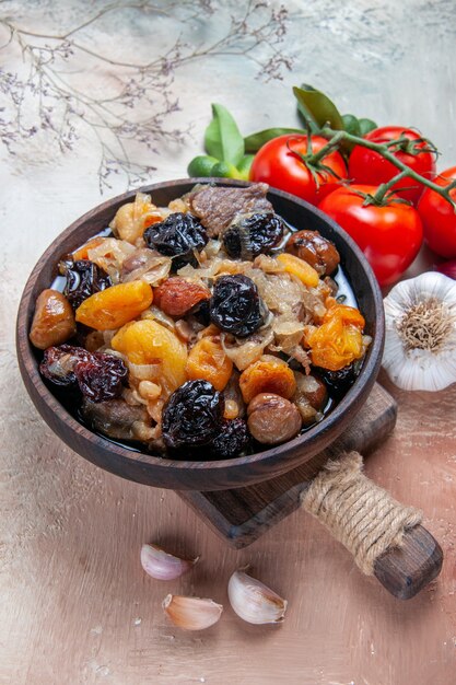 Vue rapprochée de côté bol de pilaf pilaf sur la planche de tomates avec pédicelles agrumes ail