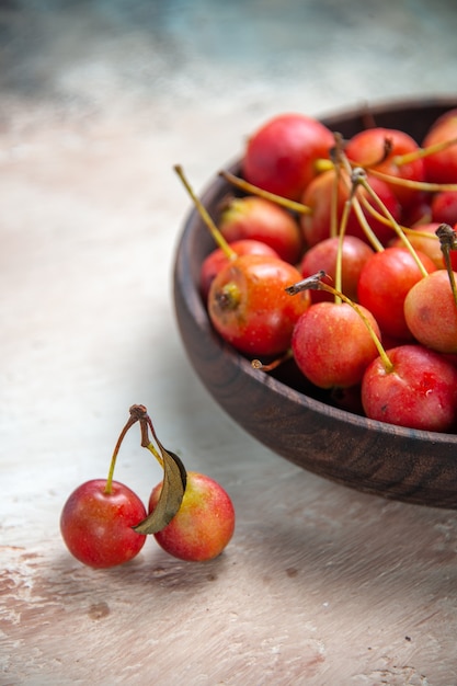 Vue rapprochée de côté cerises cerises dans le bol à côté de l'arbre abranches