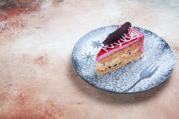 Vue rapprochée de côté un gâteau un gâteau appétissant avec du chocolat sur la plaque