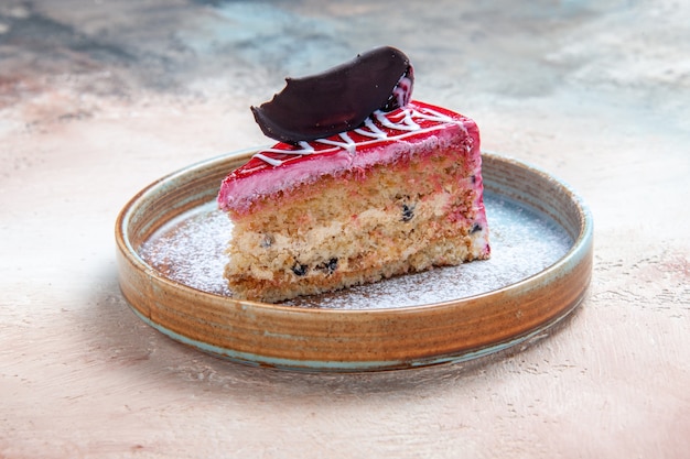 Vue rapprochée de côté un gâteau un gâteau appétissant avec du chocolat et des sauces sur la plaque