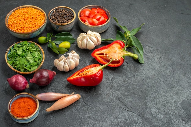 Vue rapprochée de côté légumes bol de lentilles ail herbes oignon épices tomates poivron