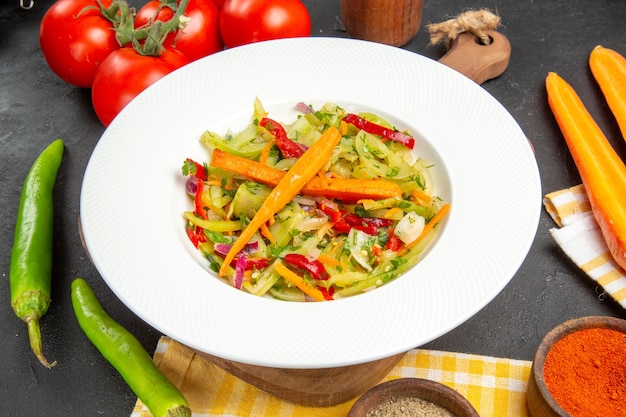 Vue rapprochée de côté légumes piments épicés salade de tomates sur la nappe de la planche à découper