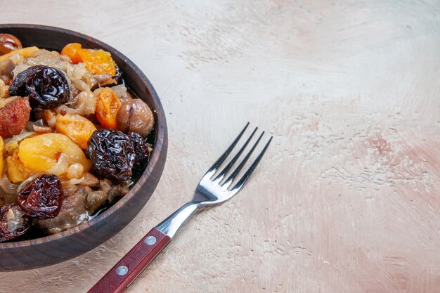 Vue rapprochée de côté riz pilaf châtaignes fruits secs dans le bol fourchette