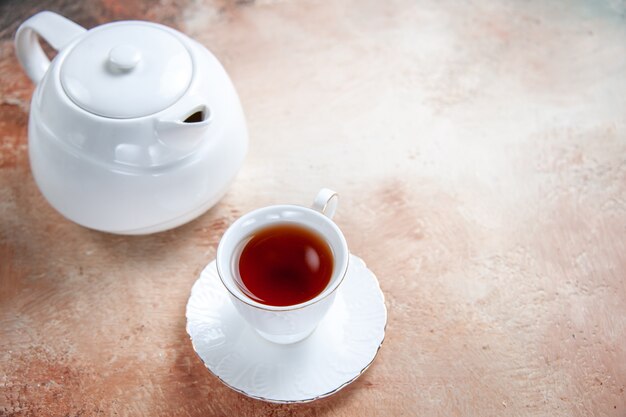 Vue rapprochée de côté une tasse de thé théière blanche une tasse de thé