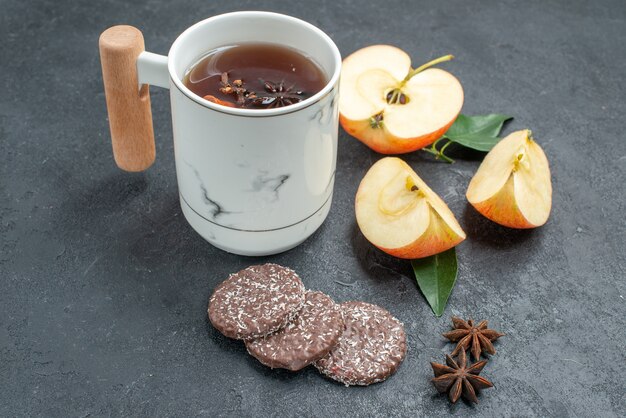 Vue rapprochée de côté une tasse de thé tranches de pomme cookies une tasse de thé à la cannelle