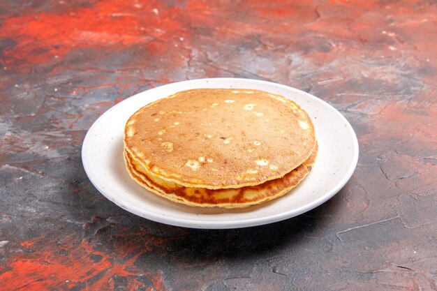 Vue rapprochée de crêpes au babeurre américain classique sur une plaque blanche sur couleur mixte