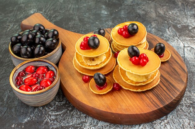 Vue rapprochée de crêpes au babeurre classiques servies avec des fruits sur fond gris